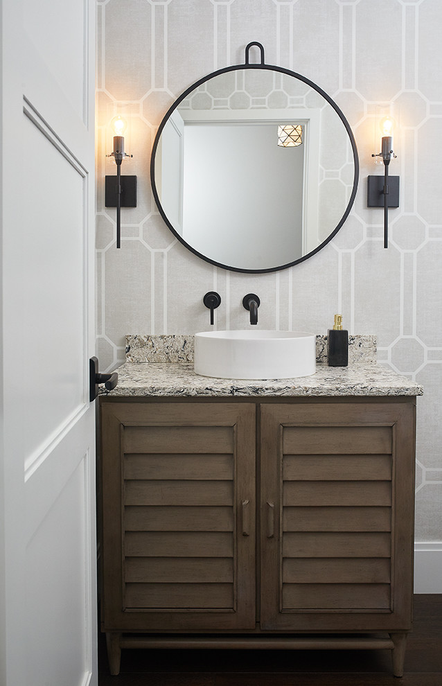 Transitional powder room in Grand Rapids with dark wood cabinets, grey walls, dark hardwood floors, a vessel sink, brown floor, a freestanding vanity, wallpaper, louvered cabinets and multi-coloured benchtops.