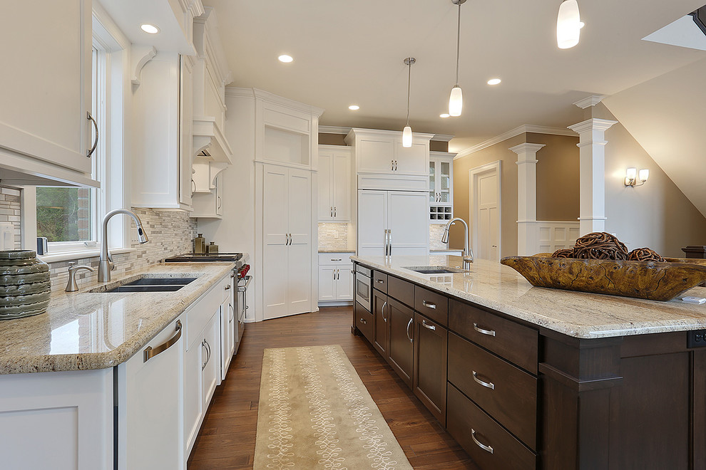 Design ideas for a large arts and crafts l-shaped eat-in kitchen in Other with a double-bowl sink, raised-panel cabinets, white cabinets, white splashback, stainless steel appliances, dark hardwood floors and with island.