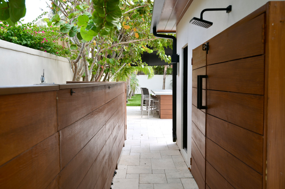 Immagine di un privacy in giardino tropicale esposto a mezz'ombra di medie dimensioni e nel cortile laterale in estate con pavimentazioni in pietra naturale e recinzione in legno
