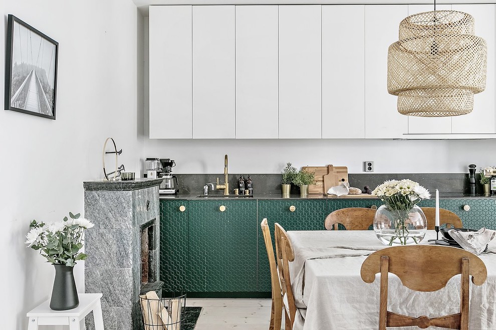 Design ideas for a mid-sized scandinavian single-wall open plan kitchen in Stockholm with a single-bowl sink, beaded inset cabinets, green cabinets, granite benchtops, black splashback, panelled appliances, light hardwood floors, no island and beige floor.