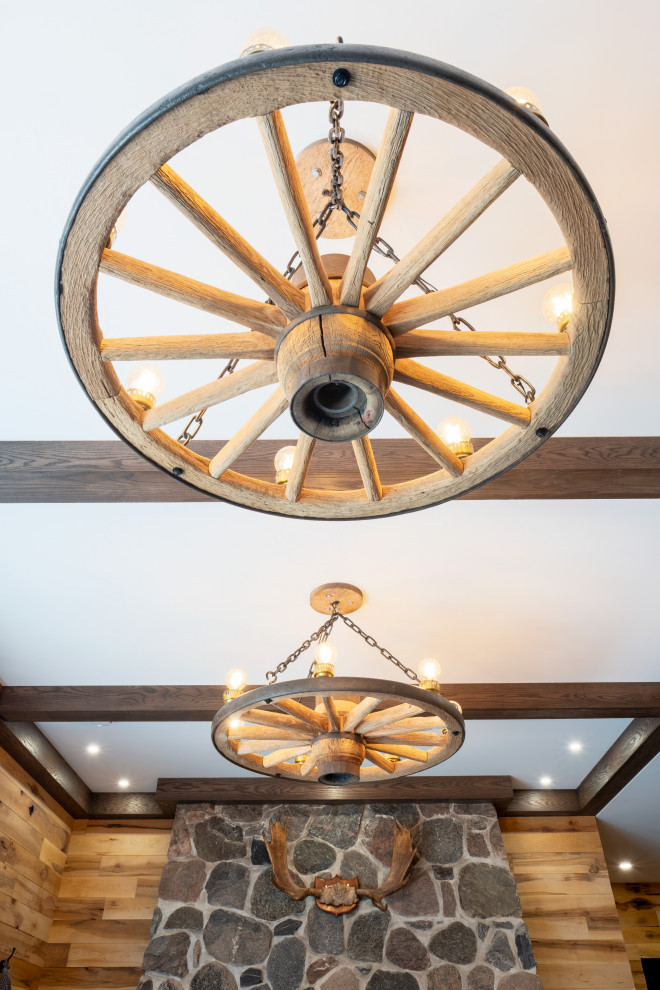 Inspiration for a large rustic walk-out vinyl floor, gray floor, exposed beam and wood wall basement remodel with a bar, multicolored walls, a standard fireplace and a stone fireplace