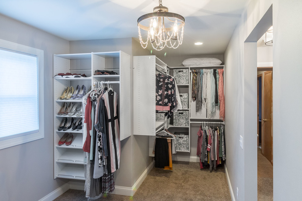 Inspiration for a mid-sized transitional gender-neutral dressing room in Other with open cabinets, white cabinets, carpet and grey floor.