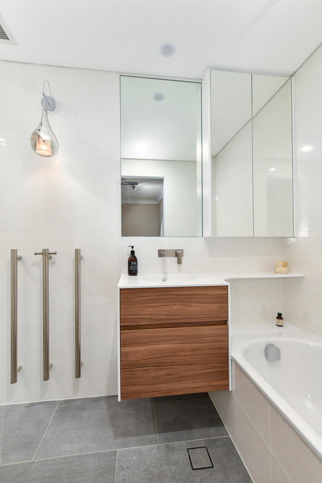 Small contemporary master bathroom in Sydney with medium wood cabinets, an alcove shower, white walls, an integrated sink, solid surface benchtops, grey floor, a hinged shower door and white benchtops.