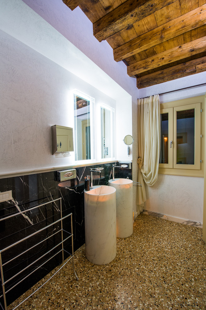 Photo of a mid-sized contemporary bathroom in Venice with black and white tile, stone slab, white walls, marble floors, a pedestal sink and marble benchtops.