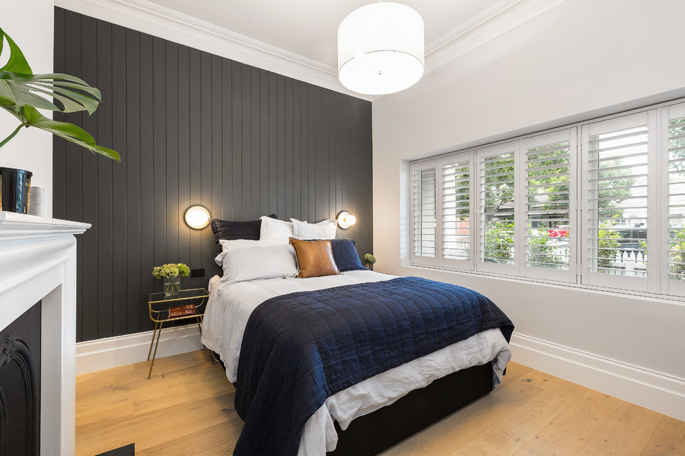 Photo of a mid-sized contemporary master bedroom in Melbourne with grey walls, light hardwood floors, a standard fireplace and a metal fireplace surround.