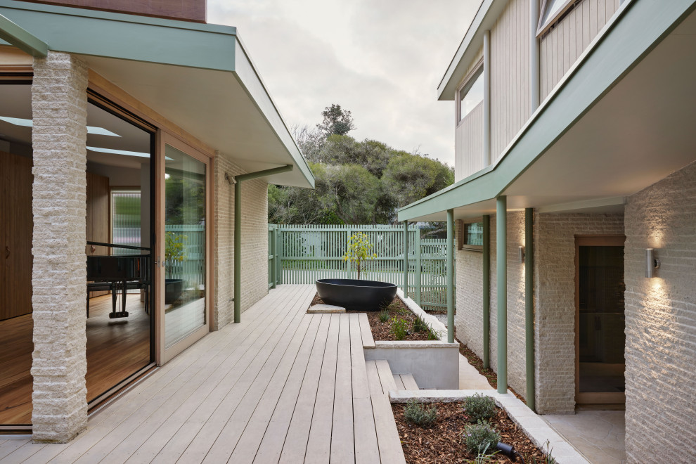 Imagen de terraza planta baja costera de tamaño medio en patio con jardín de macetas, pérgola y barandilla de madera