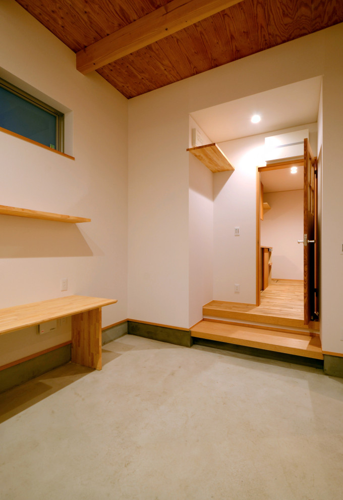 This is an example of a mid-sized modern men's walk-in wardrobe with grey floor and exposed beam.