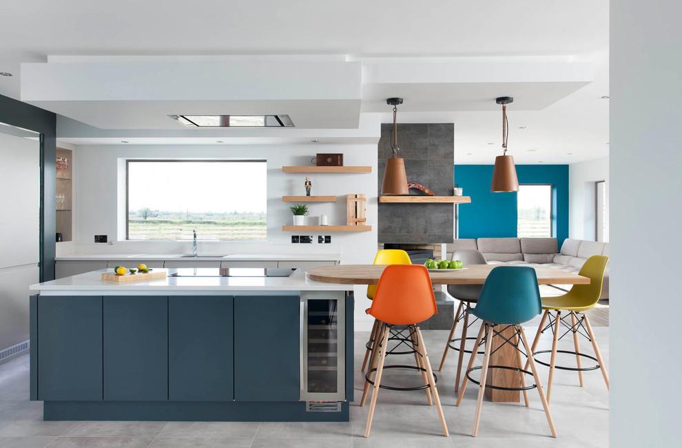 This is an example of a contemporary open plan kitchen with flat-panel cabinets, blue cabinets, quartzite benchtops, stainless steel appliances, with island, grey floor, an undermount sink and window splashback.