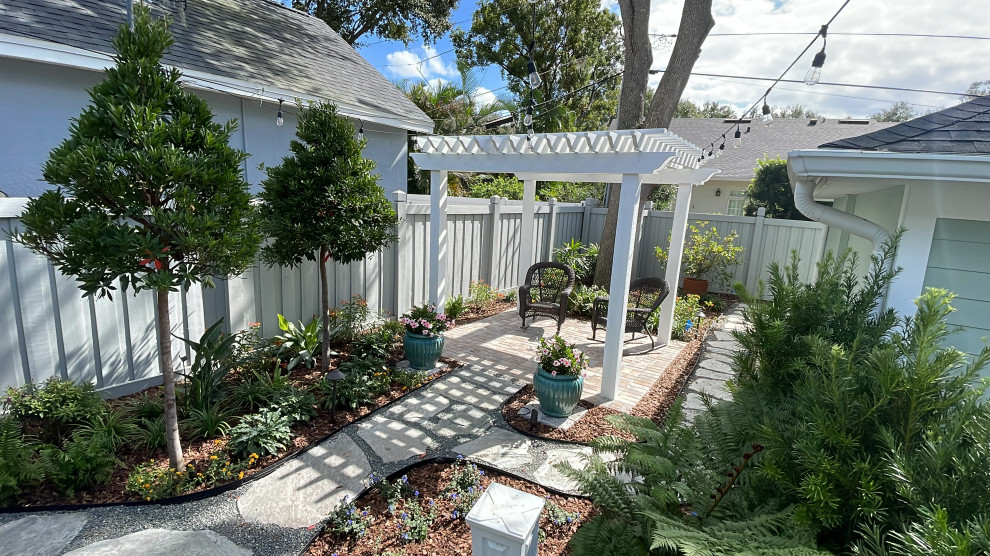Idee per un piccolo giardino classico esposto in pieno sole dietro casa con pavimentazioni in pietra naturale e recinzione in legno