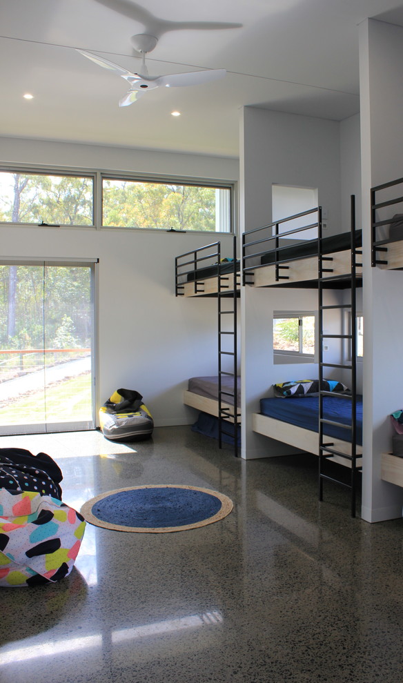 This is an example of a small contemporary gender-neutral kids' room in Other with white walls and concrete floors.