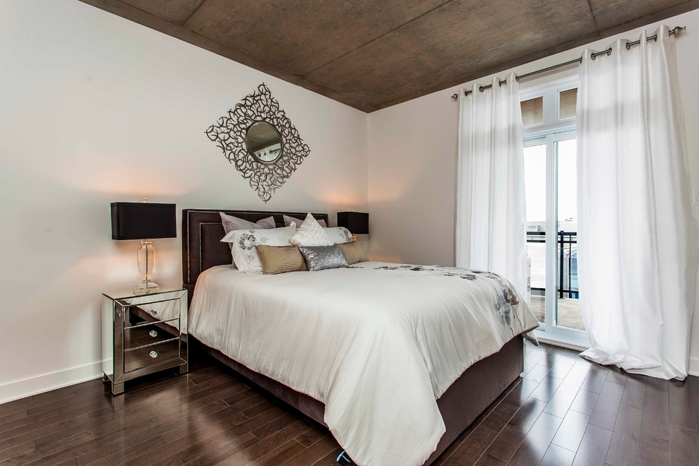 This is an example of a mid-sized contemporary master bedroom in Montreal with white walls and dark hardwood floors.