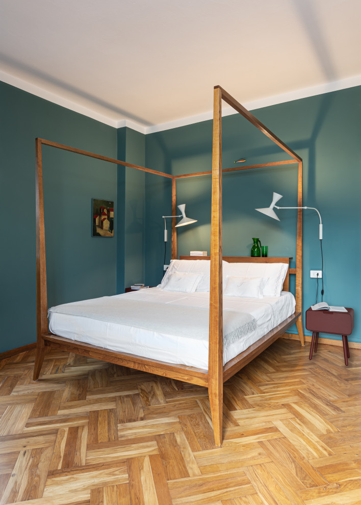 Réalisation d'une grande chambre parentale vintage avec un mur vert, un sol en bois brun et un sol beige.