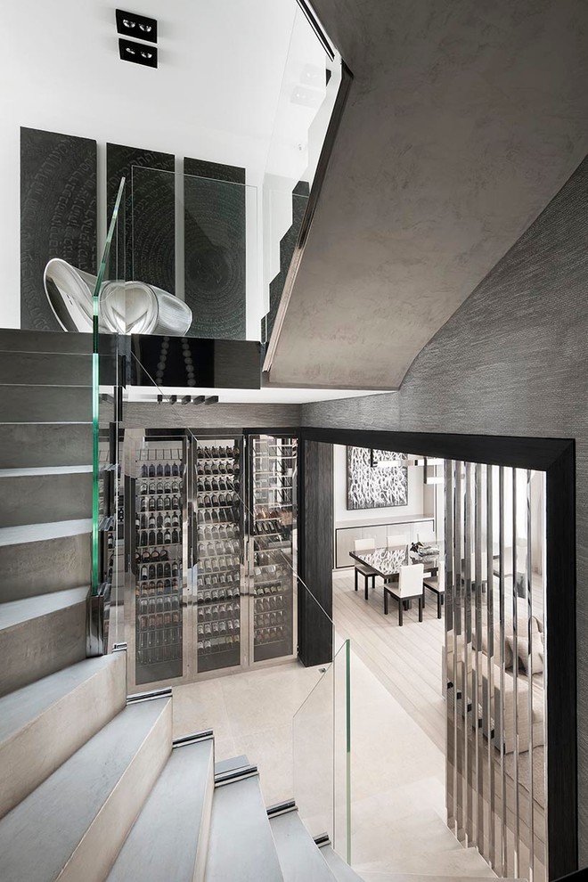 This is an example of a mid-sized modern wine cellar in Paris with display racks.