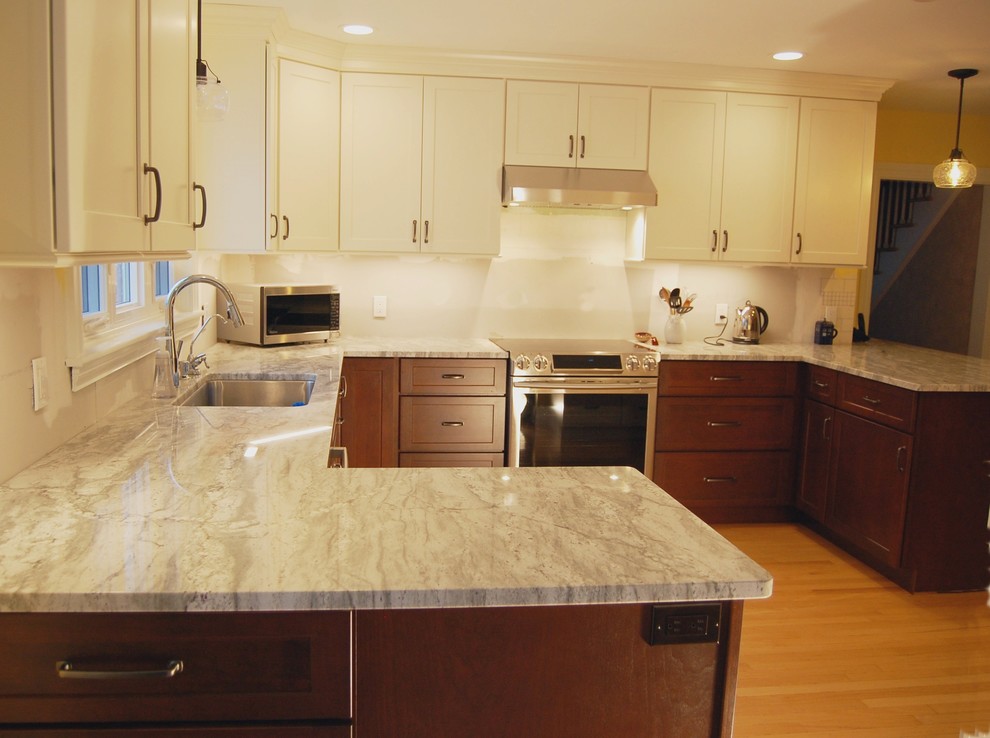 Mid-sized transitional u-shaped light wood floor eat-in kitchen photo in Boston with an undermount sink, shaker cabinets, white cabinets, quartz countertops, stainless steel appliances and a peninsula