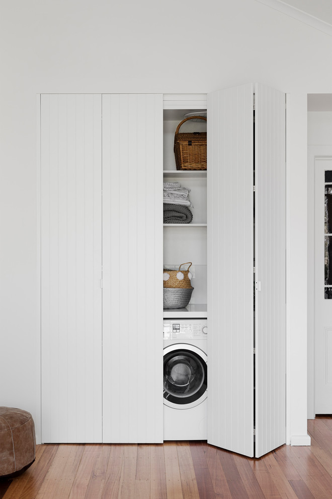 Design ideas for a mid-sized contemporary laundry cupboard in Melbourne with a drop-in sink, shaker cabinets, granite benchtops, white walls, medium hardwood floors, a side-by-side washer and dryer, brown floor and white benchtop.