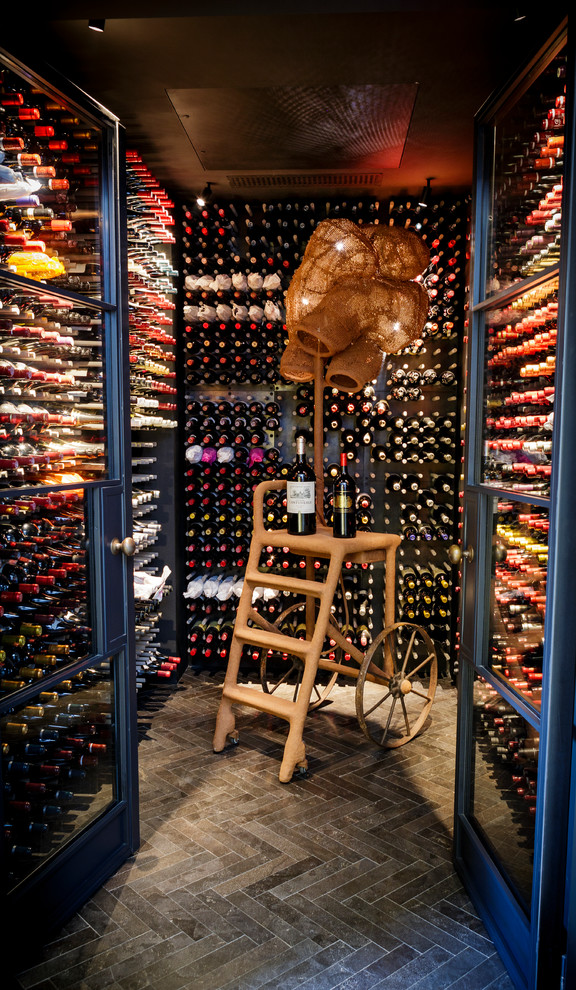 This is an example of a contemporary wine cellar in London with storage racks and grey floor.