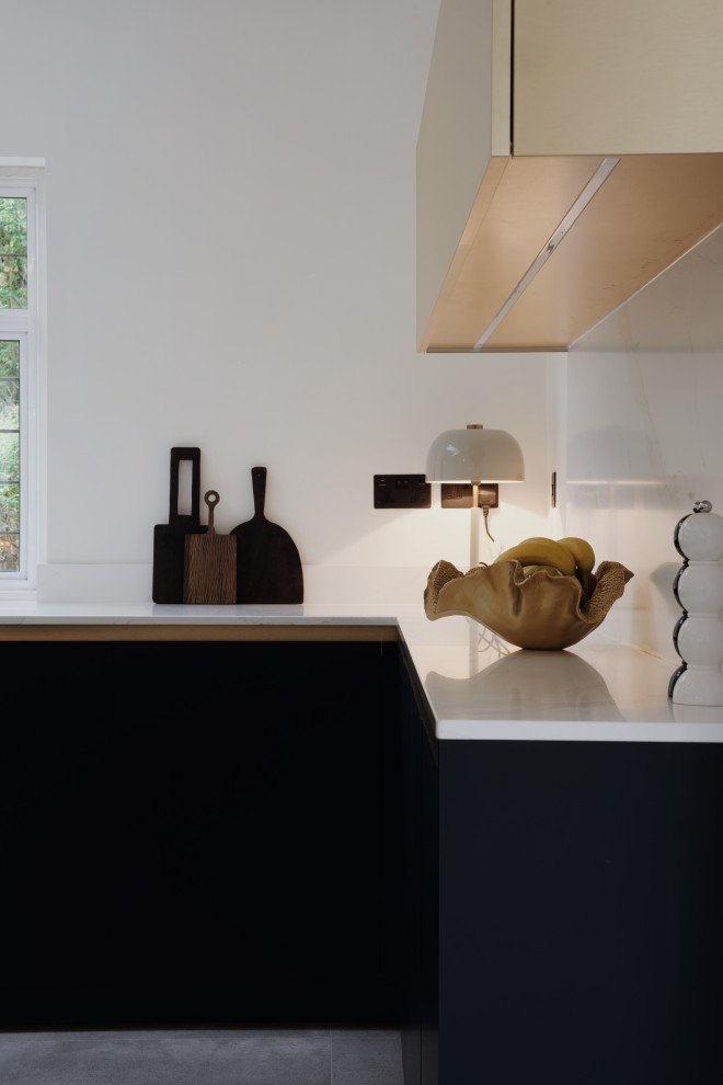 Inspiration for a medium sized modern u-shaped kitchen/diner in London with flat-panel cabinets, blue cabinets, quartz worktops, white splashback, slate flooring, an island, beige floors and white worktops.