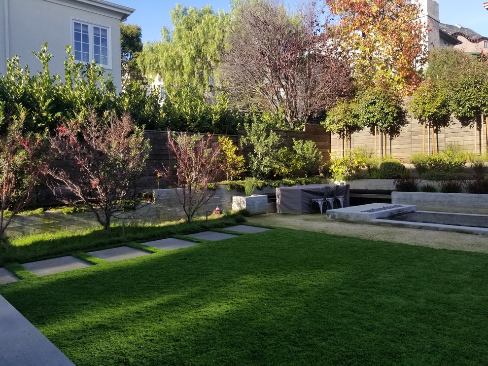 Inspiration for a large modern backyard partial sun garden in San Francisco with a retaining wall and decking.