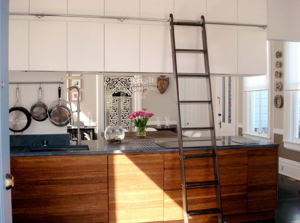 Inspiration for an eclectic eat-in kitchen in San Francisco with flat-panel cabinets, white cabinets and blue benchtop.