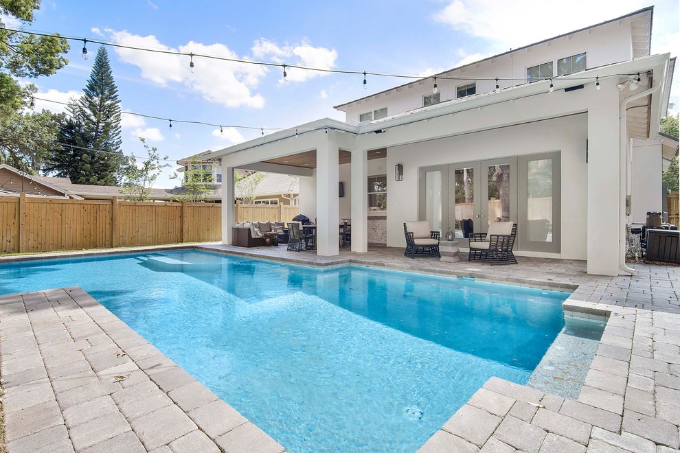 Design ideas for a large beach style backyard rectangular pool in Orlando with concrete pavers.