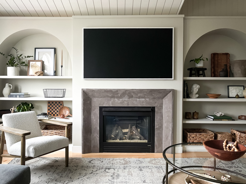 Cette photo montre un salon chic de taille moyenne et ouvert avec un mur gris, parquet clair, une cheminée standard, un manteau de cheminée en plâtre, un téléviseur fixé au mur, un plafond en lambris de bois et du lambris.