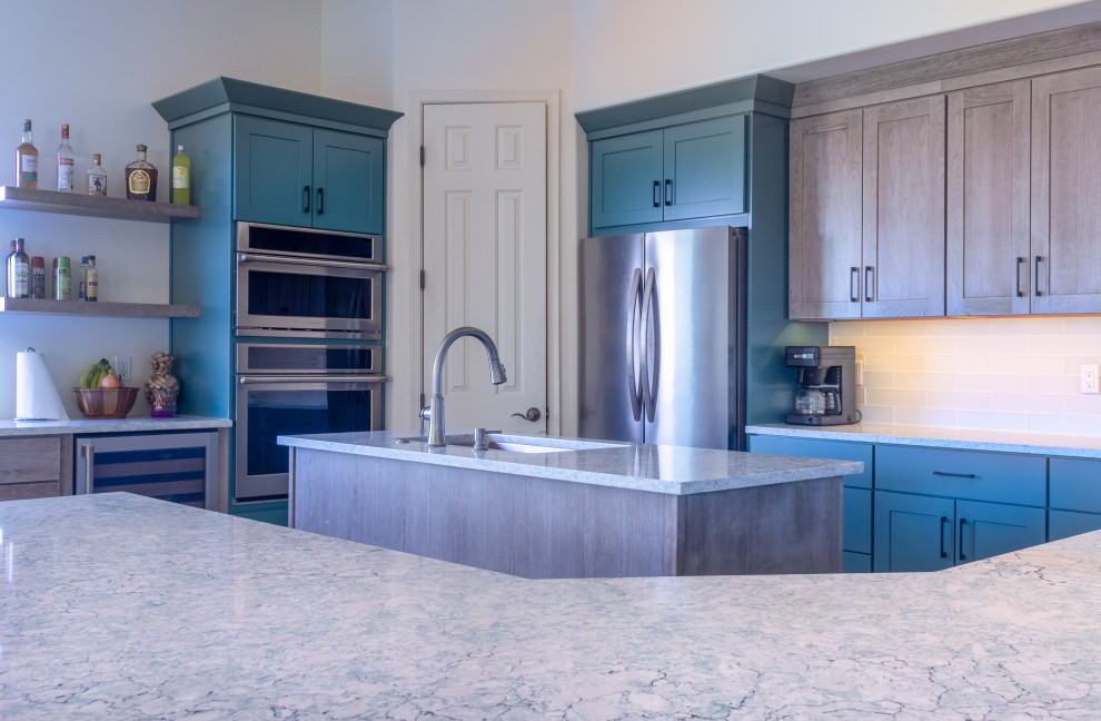 Mid-sized transitional u-shaped porcelain tile and beige floor eat-in kitchen photo with an undermount sink, flat-panel cabinets, turquoise cabinets, quartzite countertops, white backsplash, glass tile backsplash, stainless steel appliances, an island and turquoise countertops