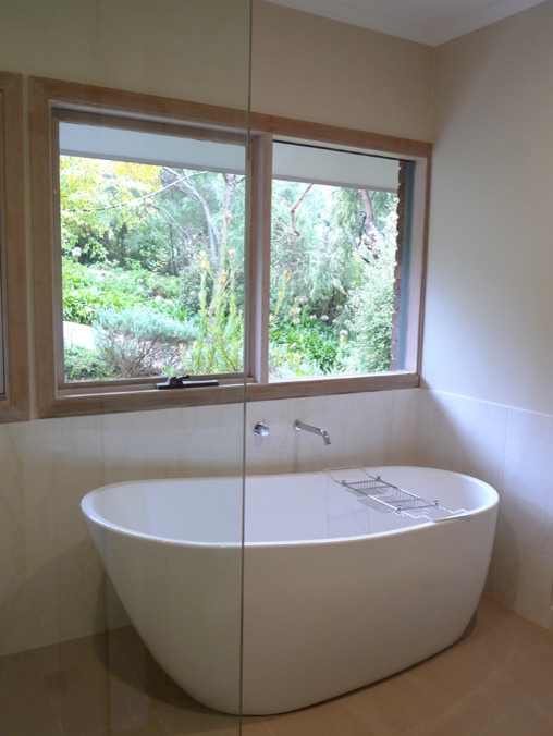 Photo of a mid-sized beach style bathroom in Melbourne with a freestanding tub, white tile, ceramic tile, beige walls, ceramic floors and a corner shower.