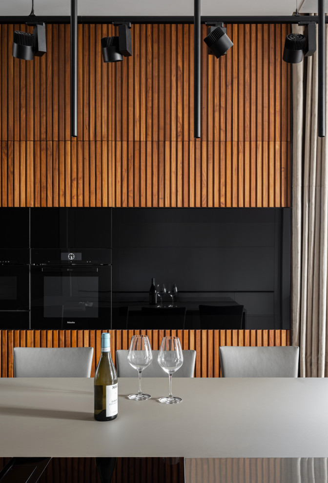 Inspiration for a medium sized contemporary single-wall kitchen/diner in Moscow with black appliances, an island, grey worktops and a feature wall.