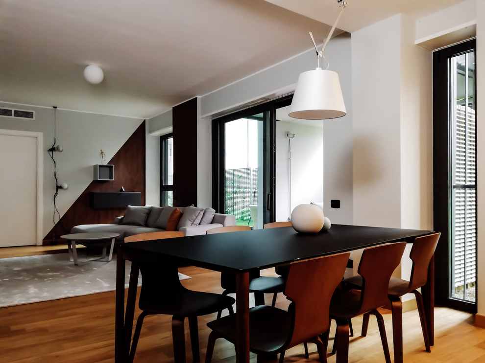 Esempio di una sala da pranzo aperta verso il soggiorno minimalista di medie dimensioni con parquet chiaro