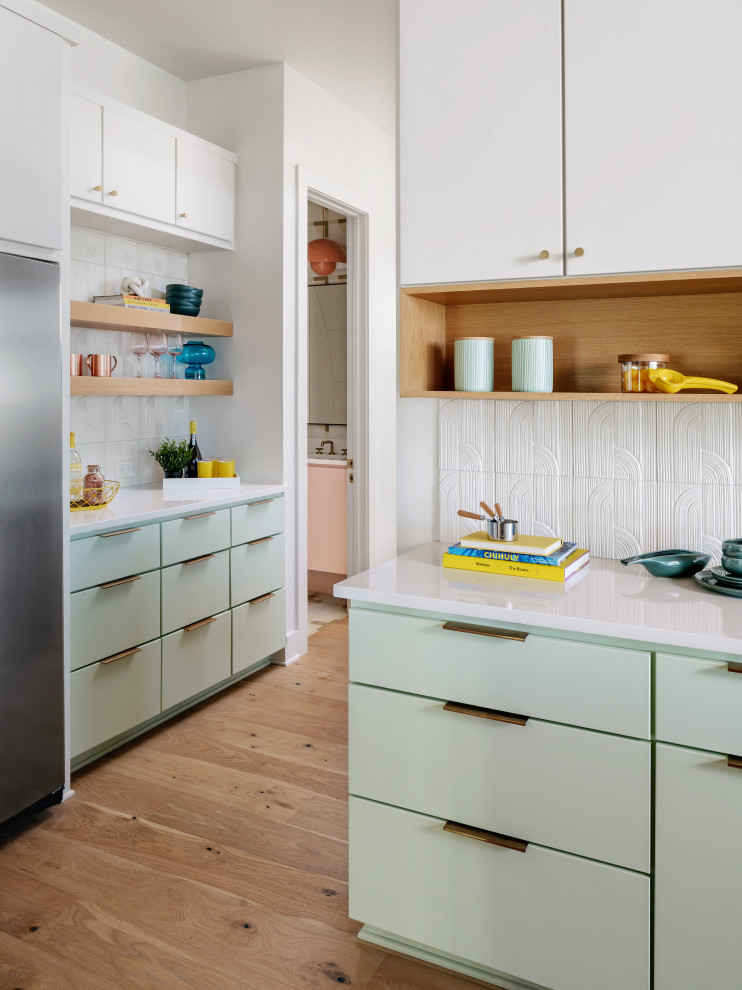 Design ideas for an expansive midcentury eat-in kitchen in Austin with a drop-in sink, flat-panel cabinets, turquoise cabinets, quartz benchtops, white splashback, porcelain splashback, stainless steel appliances, medium hardwood floors, with island, beige floor, white benchtop and wood.