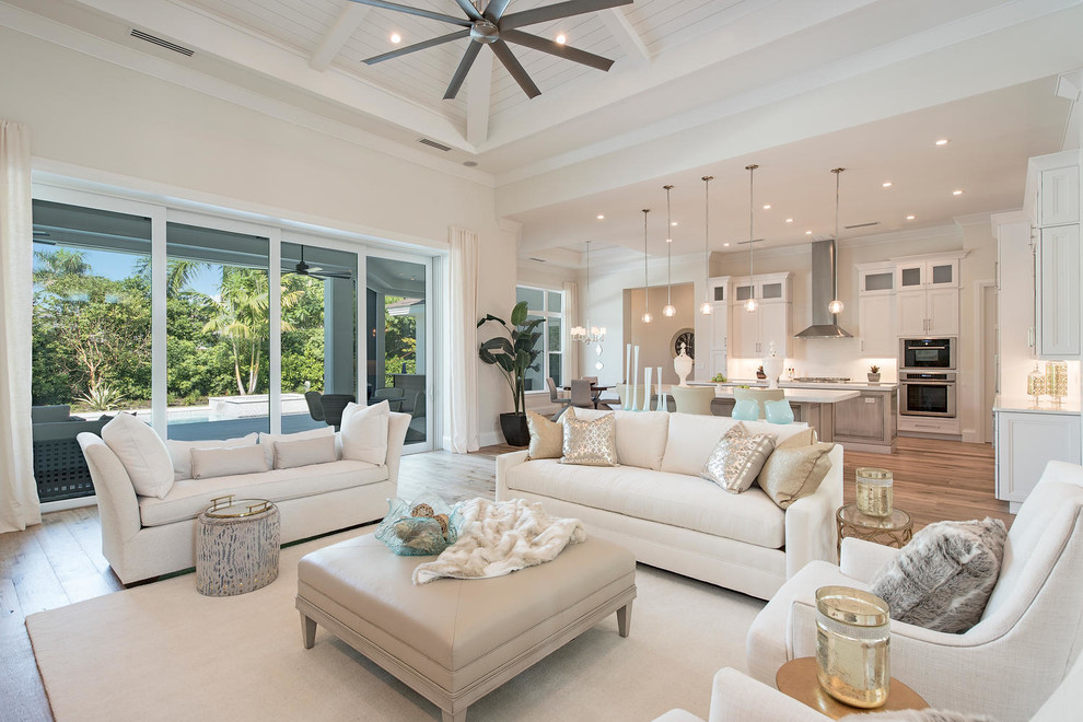 Photo of a transitional open concept living room in Miami with white walls and medium hardwood floors.