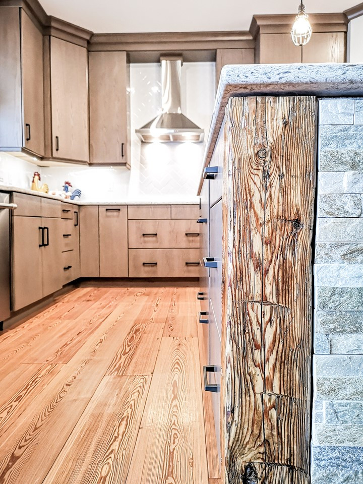 Example of a large transitional u-shaped light wood floor and brown floor eat-in kitchen design with an undermount sink, flat-panel cabinets, beige cabinets, quartz countertops, white backsplash, subway tile backsplash, stainless steel appliances, an island and white countertops