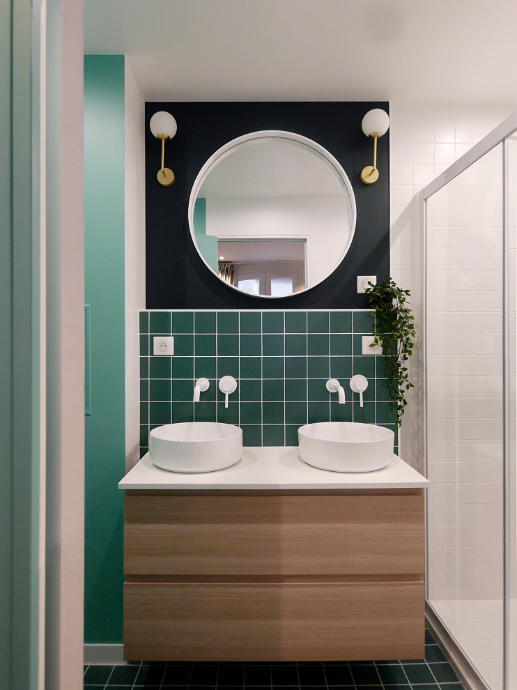 This is an example of a mid-sized contemporary master bathroom in Paris with light wood cabinets, green tile, ceramic tile, green walls, ceramic floors, a vessel sink, laminate benchtops, green floor, white benchtops, a double vanity, a floating vanity, flat-panel cabinets, an alcove shower and a sliding shower screen.