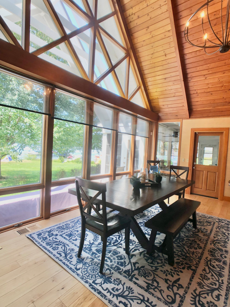 Photo of a large rustic open plan dining room in Grand Rapids with beige walls, medium hardwood flooring, a vaulted ceiling and wallpapered walls.