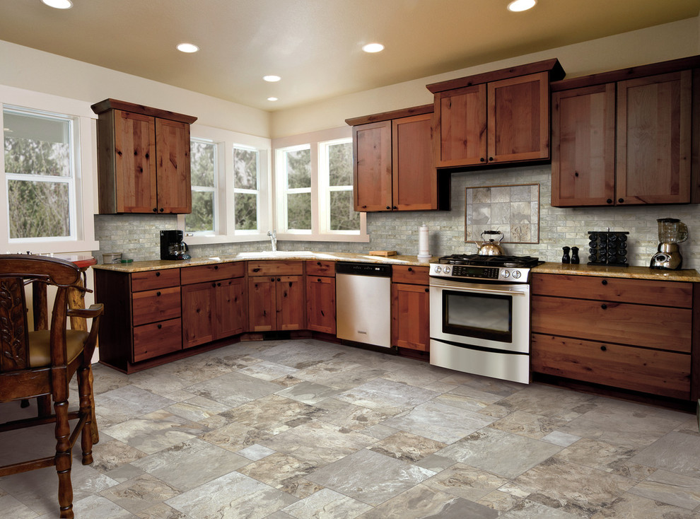 Inspiration for a mid-sized rustic l-shaped limestone floor eat-in kitchen remodel with an undermount sink, shaker cabinets, medium tone wood cabinets, granite countertops, gray backsplash, stone tile backsplash, stainless steel appliances and no island