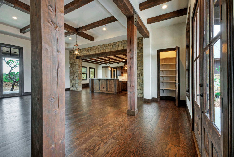 Design ideas for a country foyer in Austin with dark hardwood floors, a double front door and a dark wood front door.