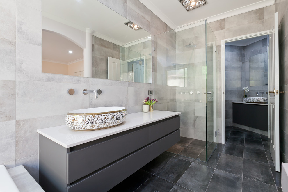 Inspiration for a mid-sized contemporary master bathroom in Perth with flat-panel cabinets, grey cabinets, a curbless shower, a one-piece toilet, gray tile, porcelain tile, grey walls, porcelain floors, a vessel sink, engineered quartz benchtops, grey floor, a hinged shower door and white benchtops.