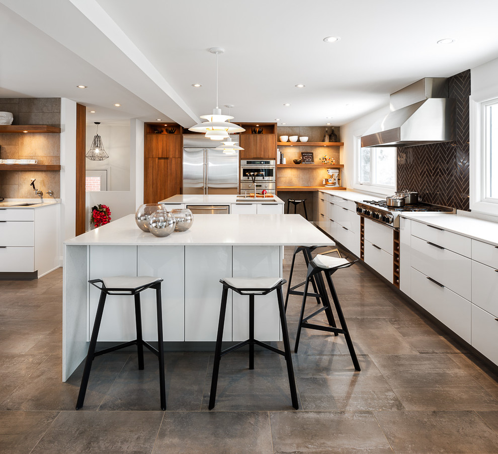This is an example of a large contemporary l-shaped eat-in kitchen in Ottawa with black splashback, an undermount sink, flat-panel cabinets, white cabinets, quartz benchtops, subway tile splashback, stainless steel appliances, multiple islands and brown floor.