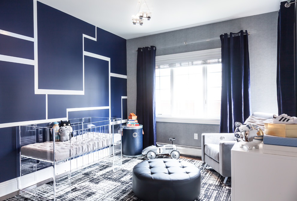 This is an example of a mid-sized modern nursery for boys in New York with blue walls and dark hardwood floors.