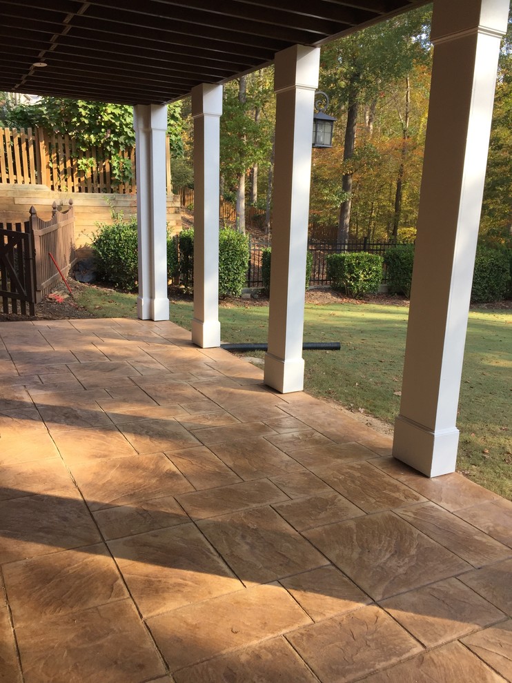 Photo of a traditional screened-in verandah in Atlanta with stamped concrete.