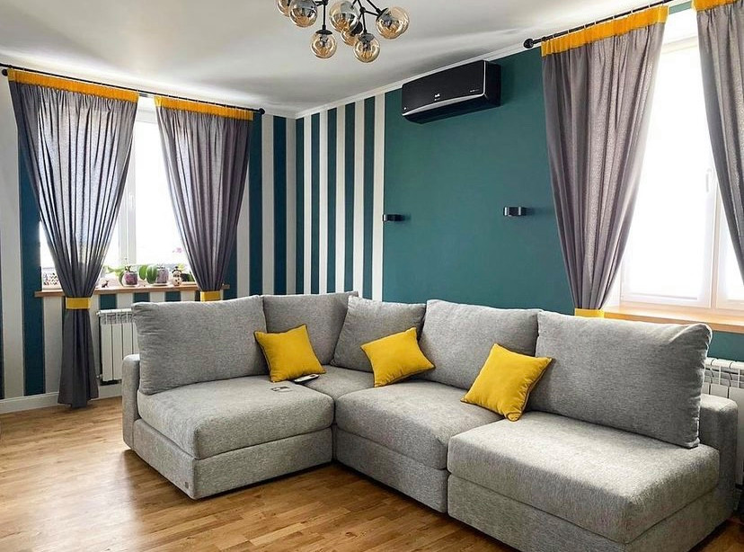 Foto di un soggiorno scandinavo di medie dimensioni con pareti verdi, pavimento in legno massello medio e TV a parete