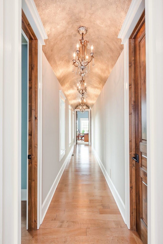 Design ideas for a large transitional hallway in Cleveland with beige walls and light hardwood floors.