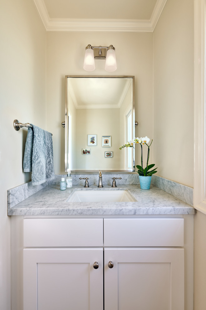 Exemple d'un petit WC et toilettes chic avec un placard à porte shaker, des portes de placard blanches, un mur blanc, un lavabo encastré, un plan de toilette en marbre, un plan de toilette gris et meuble-lavabo encastré.