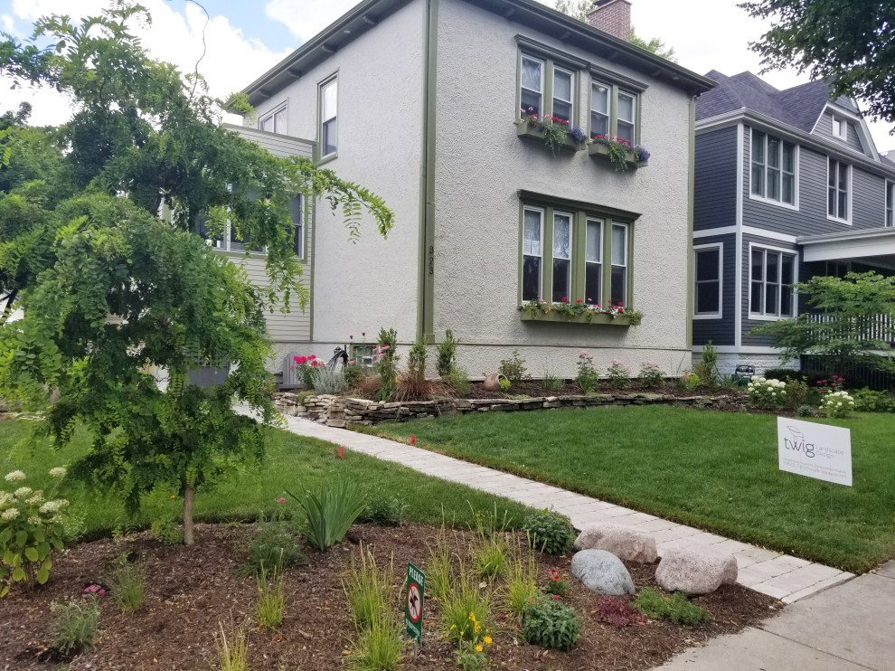 This is an example of a mid-sized contemporary front yard partial sun xeriscape in Chicago with with flowerbed and concrete pavers.