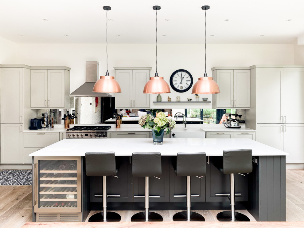Inspiration for a large contemporary l-shaped open plan kitchen in London with an undermount sink, shaker cabinets, grey cabinets, marble benchtops, metallic splashback, glass sheet splashback, stainless steel appliances, medium hardwood floors, with island, brown floor and white benchtop.