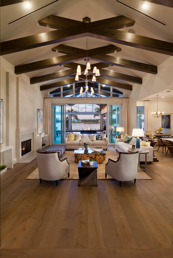 Inspiration for an expansive transitional formal open concept living room in Tampa with beige walls, medium hardwood floors, a standard fireplace, a stone fireplace surround and brown floor.