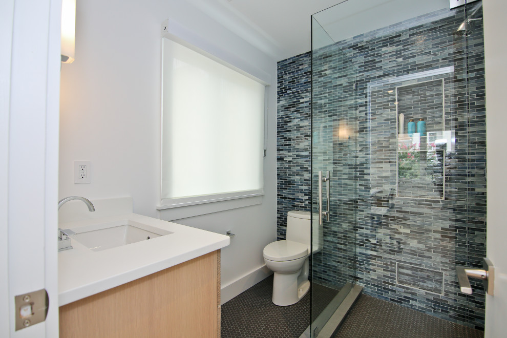 Exempel på ett litet modernt vit vitt badrum för barn, med en hörndusch, en toalettstol med hel cisternkåpa, blå kakel, glaskakel, klinkergolv i keramik, ett undermonterad handfat, bänkskiva i kvarts, grått golv och dusch med gångjärnsdörr