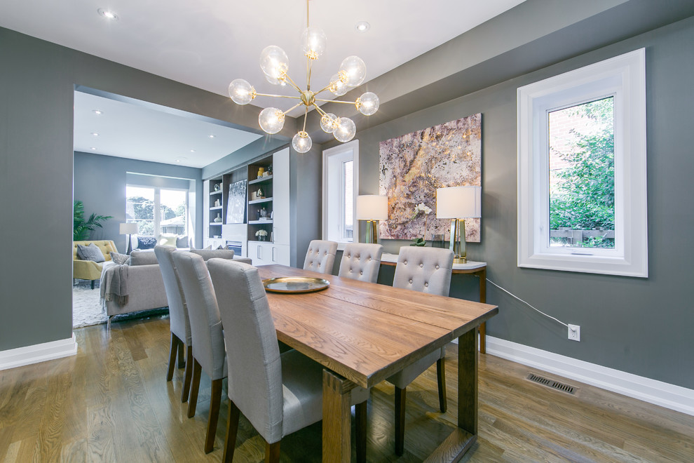 Photo of a mid-sized contemporary separate dining room in Toronto with grey walls, medium hardwood floors, no fireplace and brown floor.