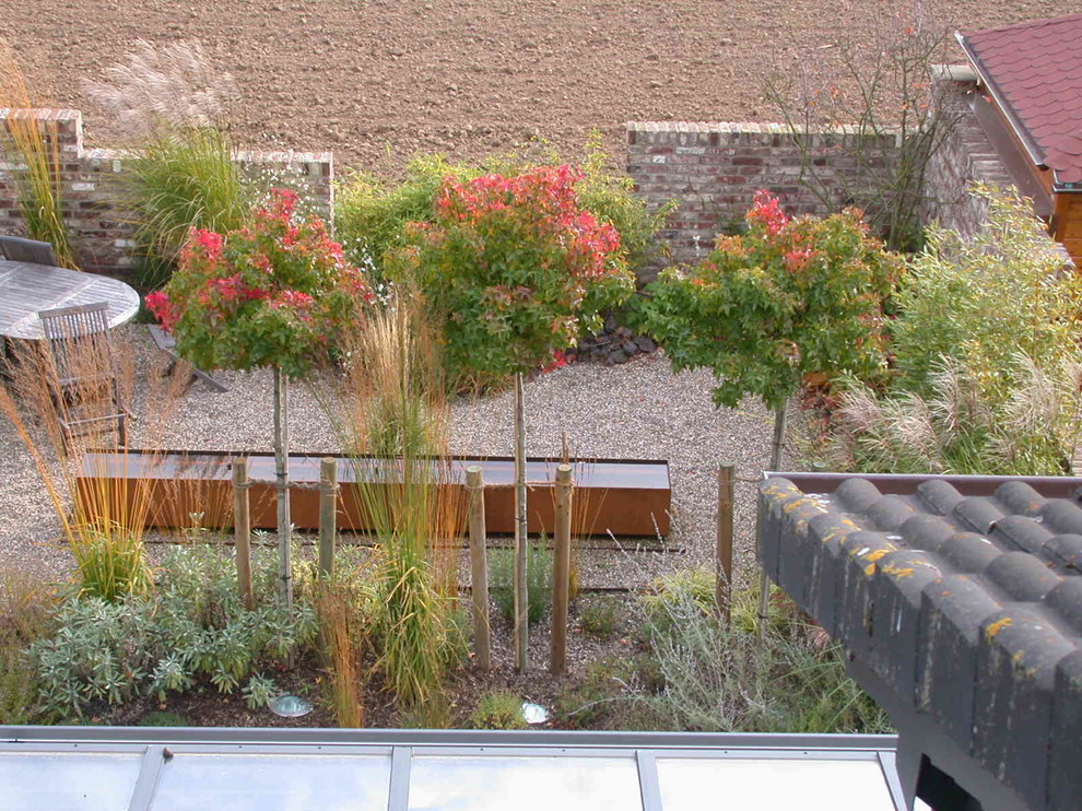 Photo of a mid-sized mediterranean backyard full sun garden for fall in Dusseldorf with natural stone pavers.