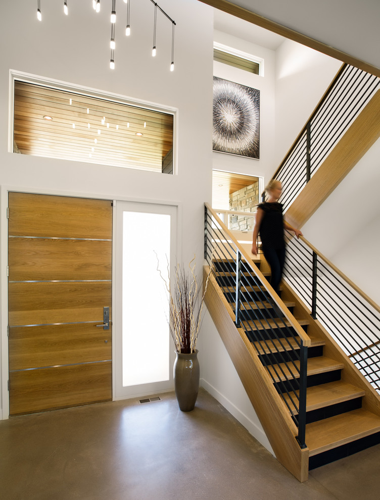 Design ideas for a mid-sized contemporary foyer in Denver with white walls, concrete floors, a single front door, a medium wood front door and beige floor.